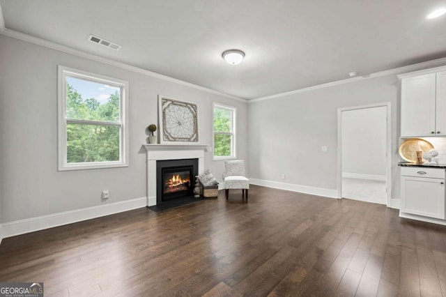 unfurnished living room with a fireplace with flush hearth, ornamental molding, dark wood finished floors, and visible vents