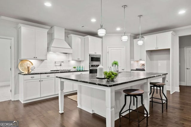 kitchen featuring white cabinets, stainless steel appliances, custom exhaust hood, and ornamental molding