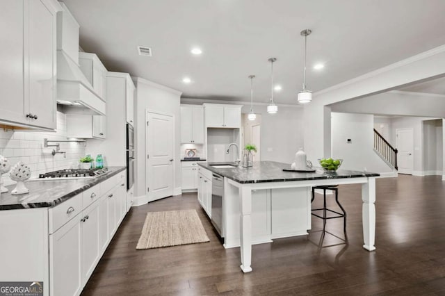 kitchen featuring visible vents, decorative backsplash, a spacious island, a sink, and dishwasher