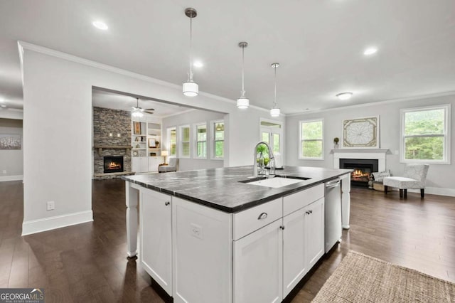 kitchen with a sink, a warm lit fireplace, and open floor plan