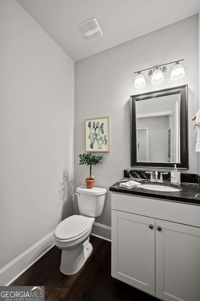 bathroom with visible vents, wood finished floors, baseboards, vanity, and toilet