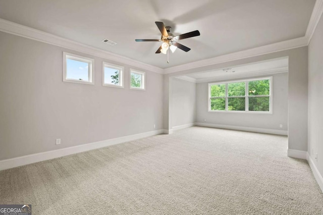 spare room with visible vents, ornamental molding, and a ceiling fan