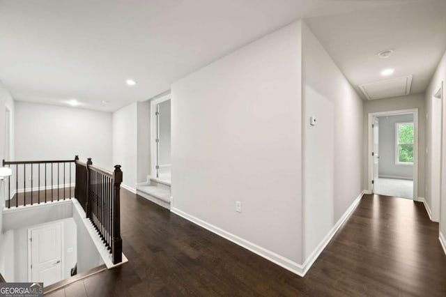 hallway featuring attic access, wood finished floors, baseboards, an upstairs landing, and recessed lighting