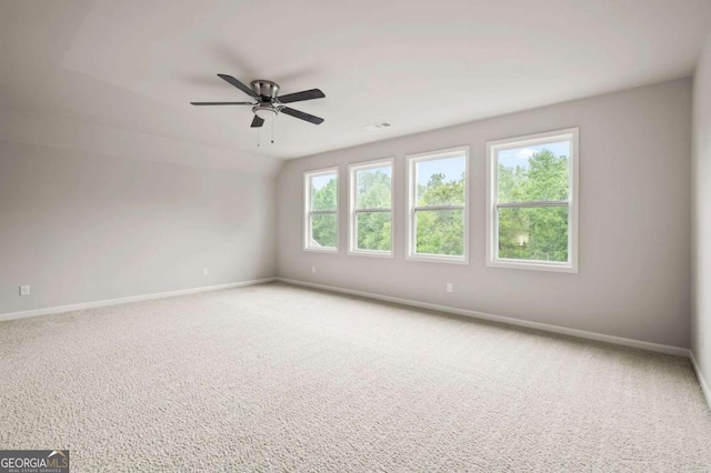 spare room with baseboards, ceiling fan, carpet floors, and visible vents