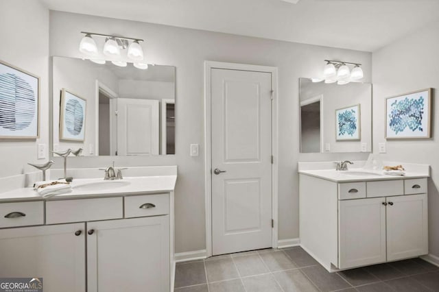 bathroom with tile patterned flooring, a sink, and two vanities