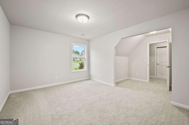 bonus room featuring baseboards and light colored carpet