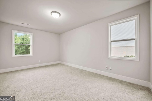 spare room featuring visible vents, carpet flooring, and baseboards