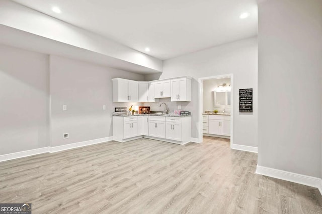 kitchen with baseboards, recessed lighting, light wood-style flooring, and white cabinetry