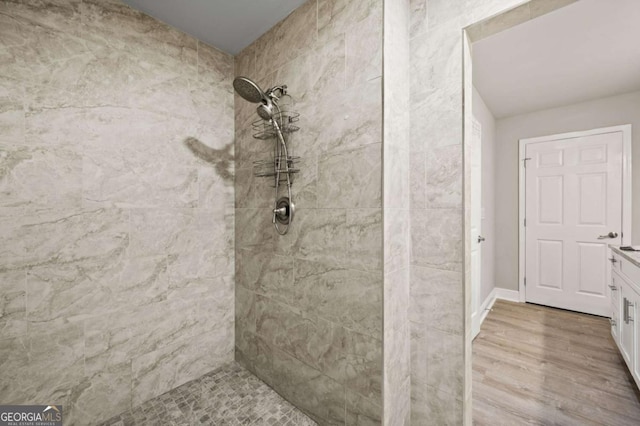 bathroom featuring a tile shower and wood finished floors