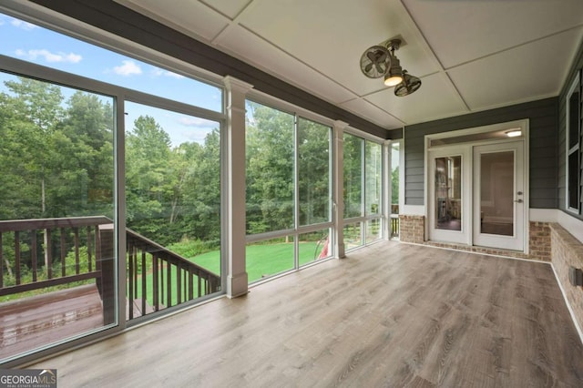unfurnished sunroom with ceiling fan and a wealth of natural light