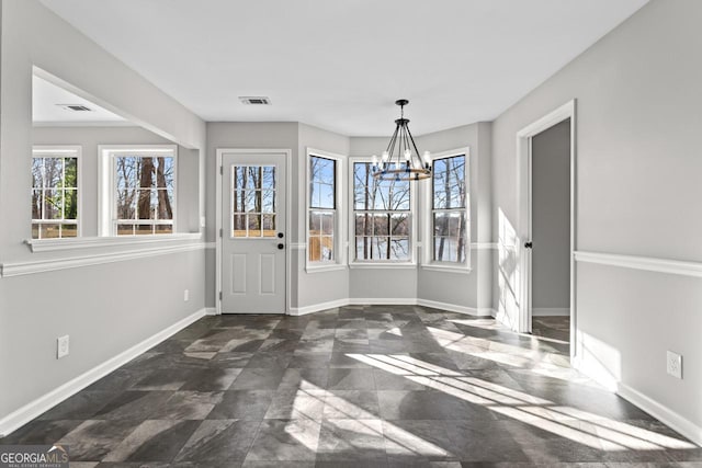 unfurnished dining area featuring a healthy amount of sunlight, baseboards, visible vents, and a notable chandelier