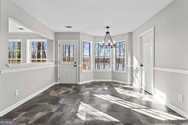unfurnished dining area featuring baseboards, a notable chandelier, a wealth of natural light, and visible vents
