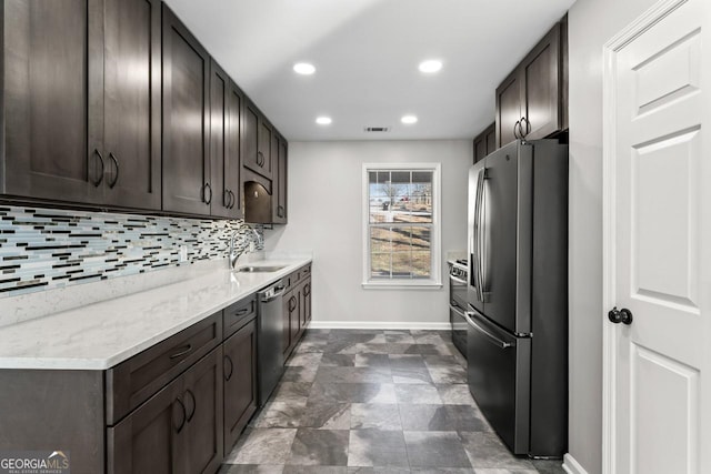 kitchen with stainless steel appliances, baseboards, a sink, and dark brown cabinets