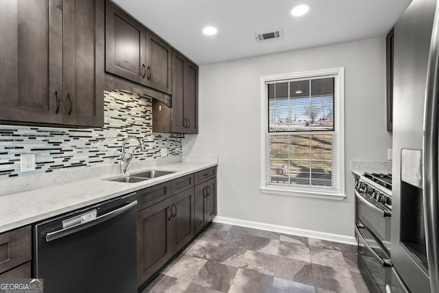 kitchen featuring a sink, dishwasher, range with two ovens, baseboards, and visible vents