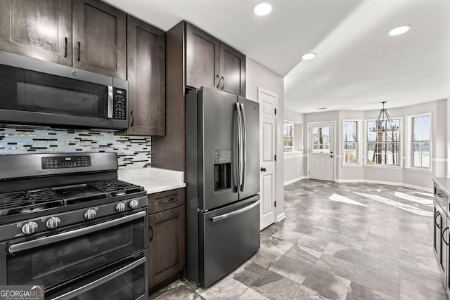 kitchen featuring light countertops, dark brown cabinetry, appliances with stainless steel finishes, and tasteful backsplash