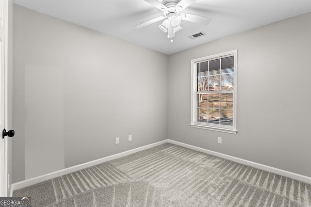 carpeted empty room featuring baseboards, visible vents, and ceiling fan