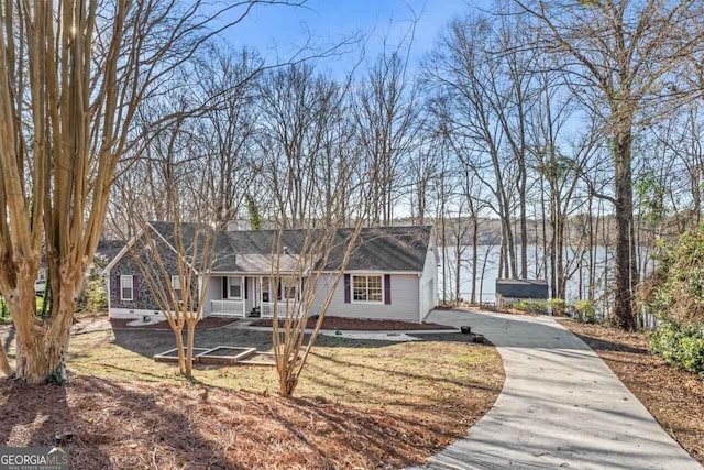 view of front facade featuring a water view and driveway