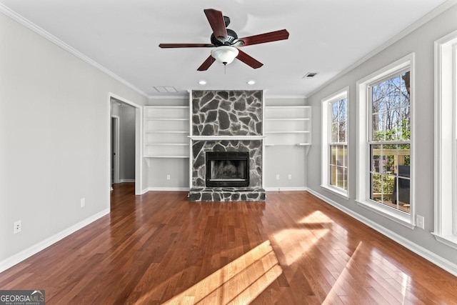 unfurnished living room featuring visible vents, ornamental molding, built in features, and a healthy amount of sunlight