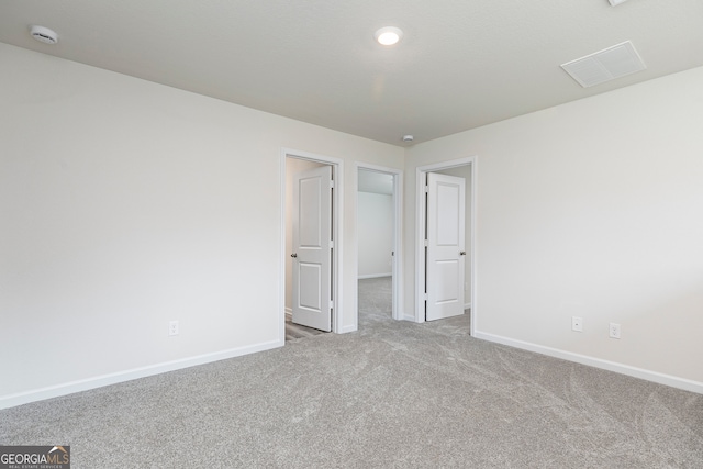 spare room featuring carpet floors, baseboards, and visible vents