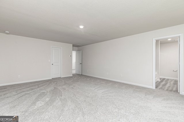 empty room with carpet floors, baseboards, and recessed lighting
