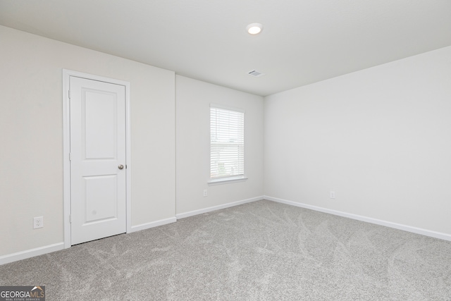 spare room featuring baseboards, carpet, and visible vents