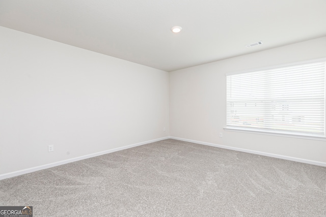 empty room featuring baseboards, recessed lighting, carpet floors, and visible vents