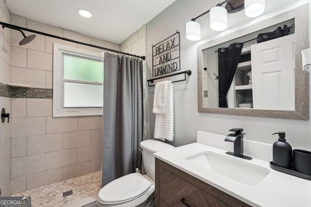full bath featuring vanity, recessed lighting, toilet, and tiled shower