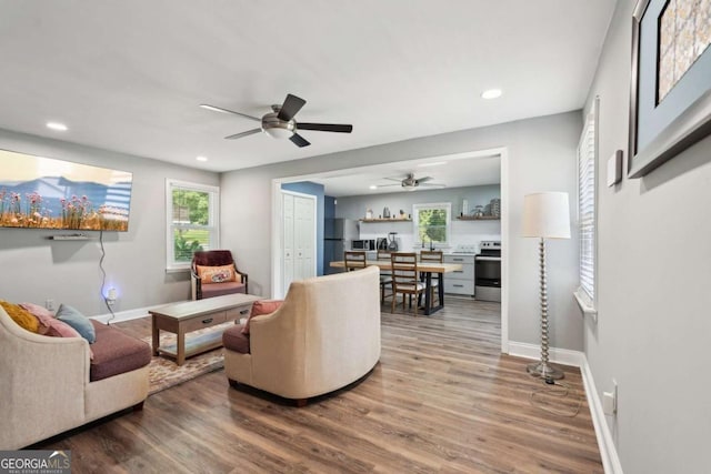living room featuring baseboards, ceiling fan, recessed lighting, and wood finished floors