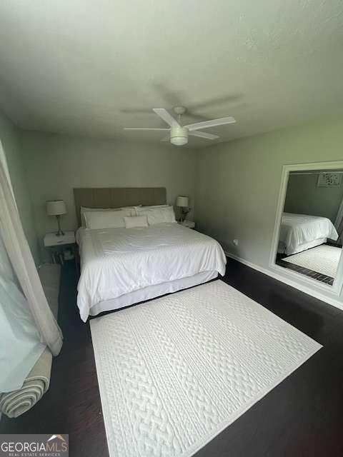 bedroom featuring baseboards, a ceiling fan, and wood finished floors
