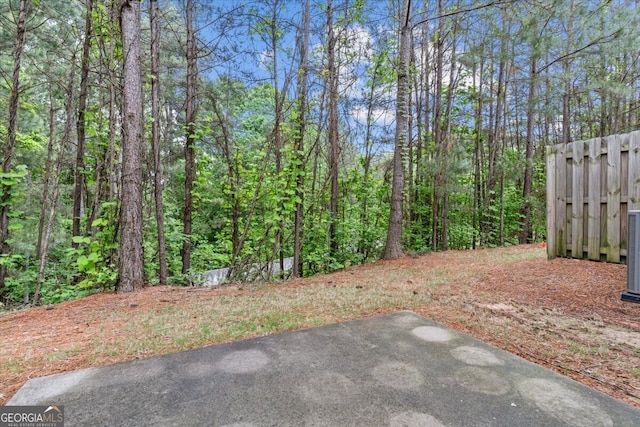 view of yard featuring a patio and a wooded view