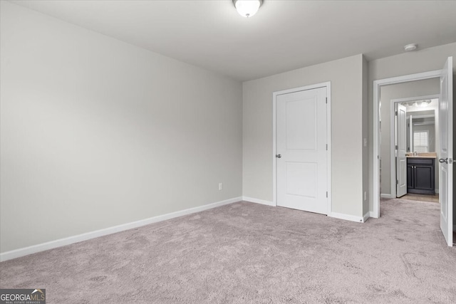 unfurnished bedroom with baseboards and light carpet