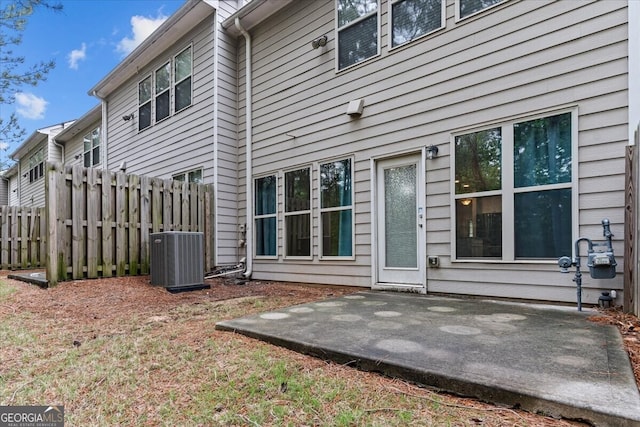 rear view of property with a patio, central AC, and fence