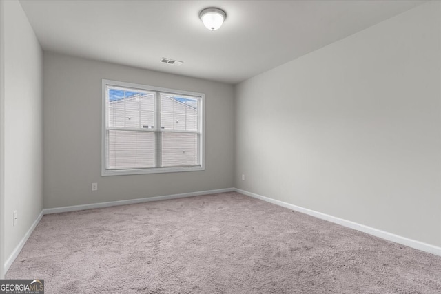unfurnished room with carpet flooring, baseboards, and visible vents