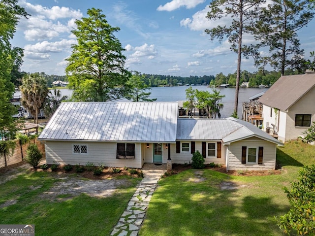 view of front of house featuring a water view, a front yard, and metal roof