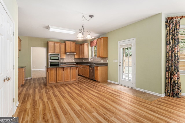 kitchen featuring light wood-style flooring, tasteful backsplash, dark countertops, and stainless steel appliances