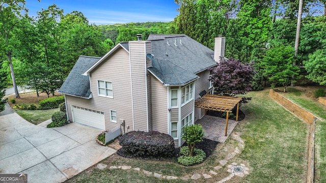 view of home's exterior with roof with shingles, a chimney, concrete driveway, and a garage