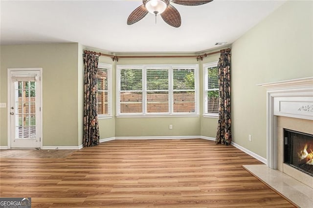 1235 Legend Run, Alpharetta, GA 30005 - unfurnished living room with a high end fireplace, ceiling fan, and light wood-style floors