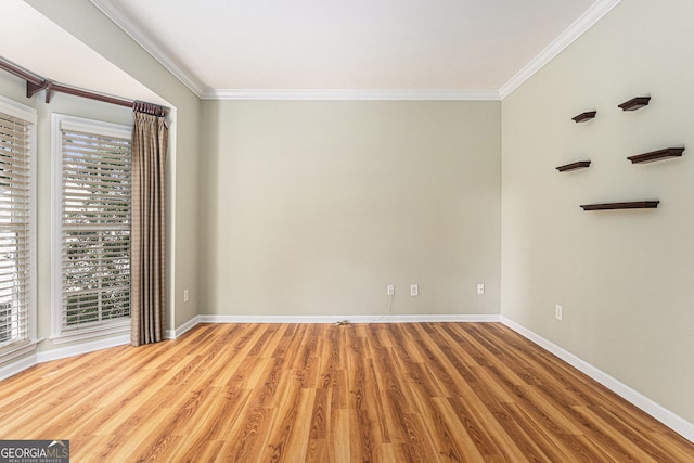 empty room featuring baseboards, ornamental molding, and wood finished floors