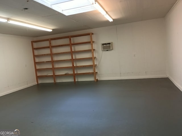 below grade area with baseboards and a wall mounted AC