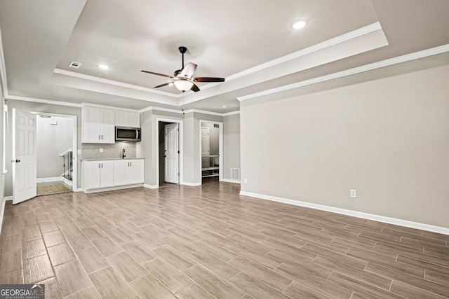 760 Swan Ln, Canton, GA 30115 - unfurnished living room with a tray ceiling, ceiling fan, light wood finished floors, crown molding, and recessed lighting