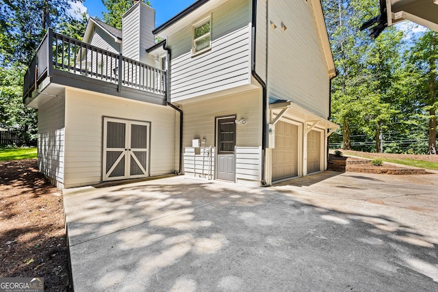 760 Swan Ln, Canton, GA 30115 - rear view of property with a balcony, an attached garage, driveway, and a chimney