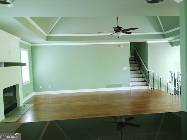 unfurnished living room featuring visible vents, crown molding, ceiling fan, and wood finished floors