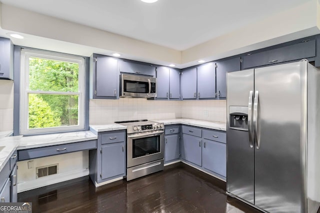 kitchen featuring backsplash, visible vents, gray cabinetry, stainless steel appliances, and dark wood-type flooring