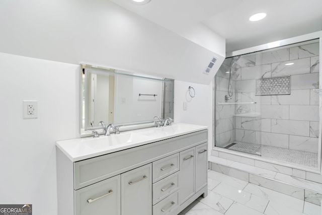 full bath featuring visible vents, double vanity, marble finish floor, tiled shower, and a sink