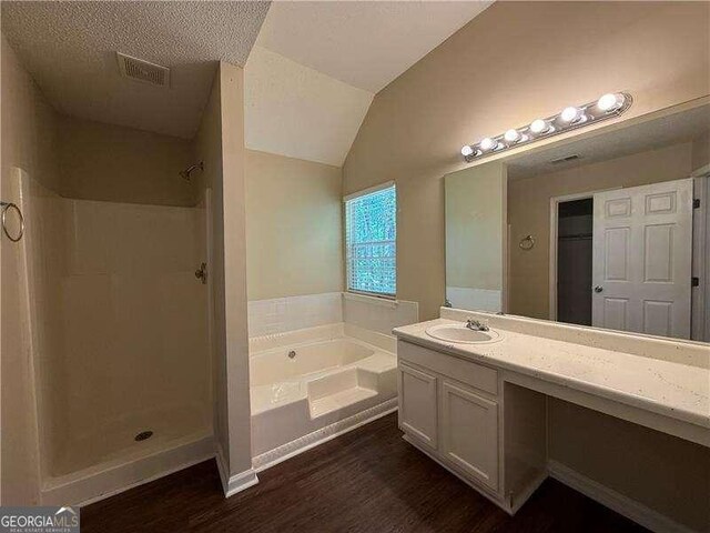 99 Ashtonbrook Dr, Mcdonough, GA 30252 - bathroom with a garden tub, visible vents, a shower stall, wood finished floors, and vanity