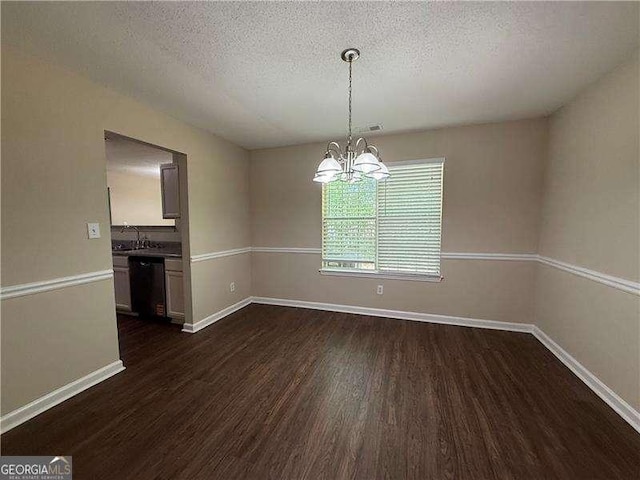 99 Ashtonbrook Dr, Mcdonough, GA 30252 - unfurnished dining area with baseboards, a textured ceiling, an inviting chandelier, and dark wood finished floors