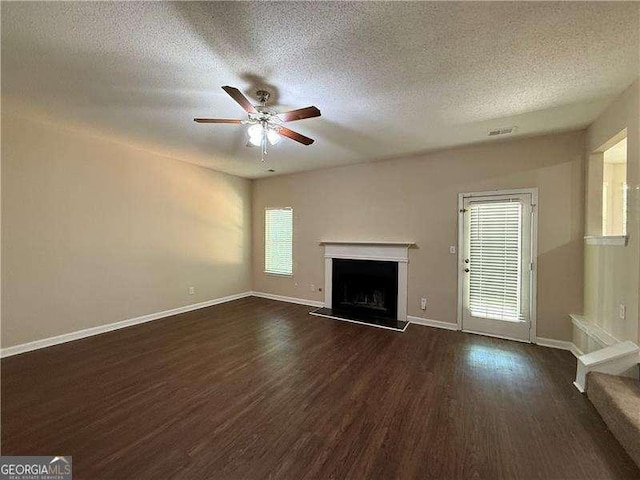 99 Ashtonbrook Dr, Mcdonough, GA 30252 - unfurnished living room featuring dark wood-type flooring, a textured ceiling, ceiling fan, and visible vents