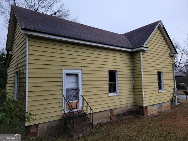 803 S Jefferson St, Dublin, GA 31021 - view of side of property featuring entry steps, crawl space, and a shingled roof