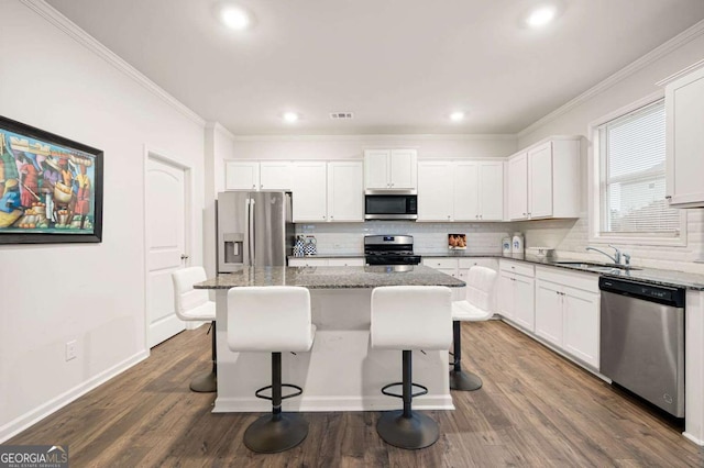 108 Berwick Xing, Dallas, GA 30157 - kitchen with ornamental molding, a kitchen bar, a sink, backsplash, and stainless steel appliances