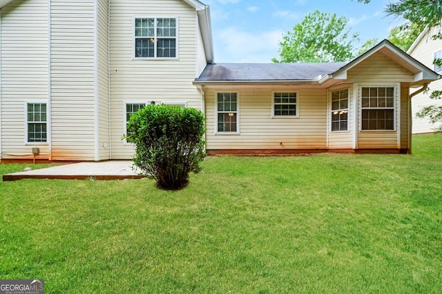 rear view of house featuring a patio and a lawn